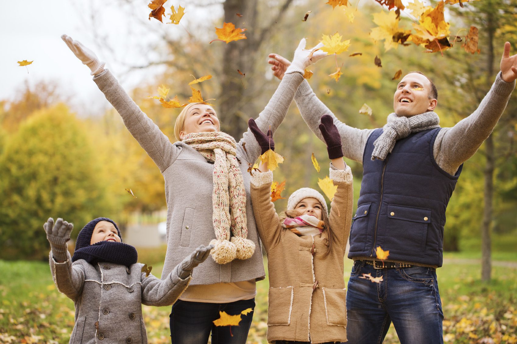 Family enjoying autumn leaves in the park.