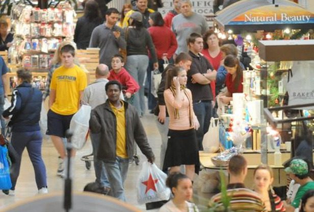 Crowded shopping mall with busy shoppers.